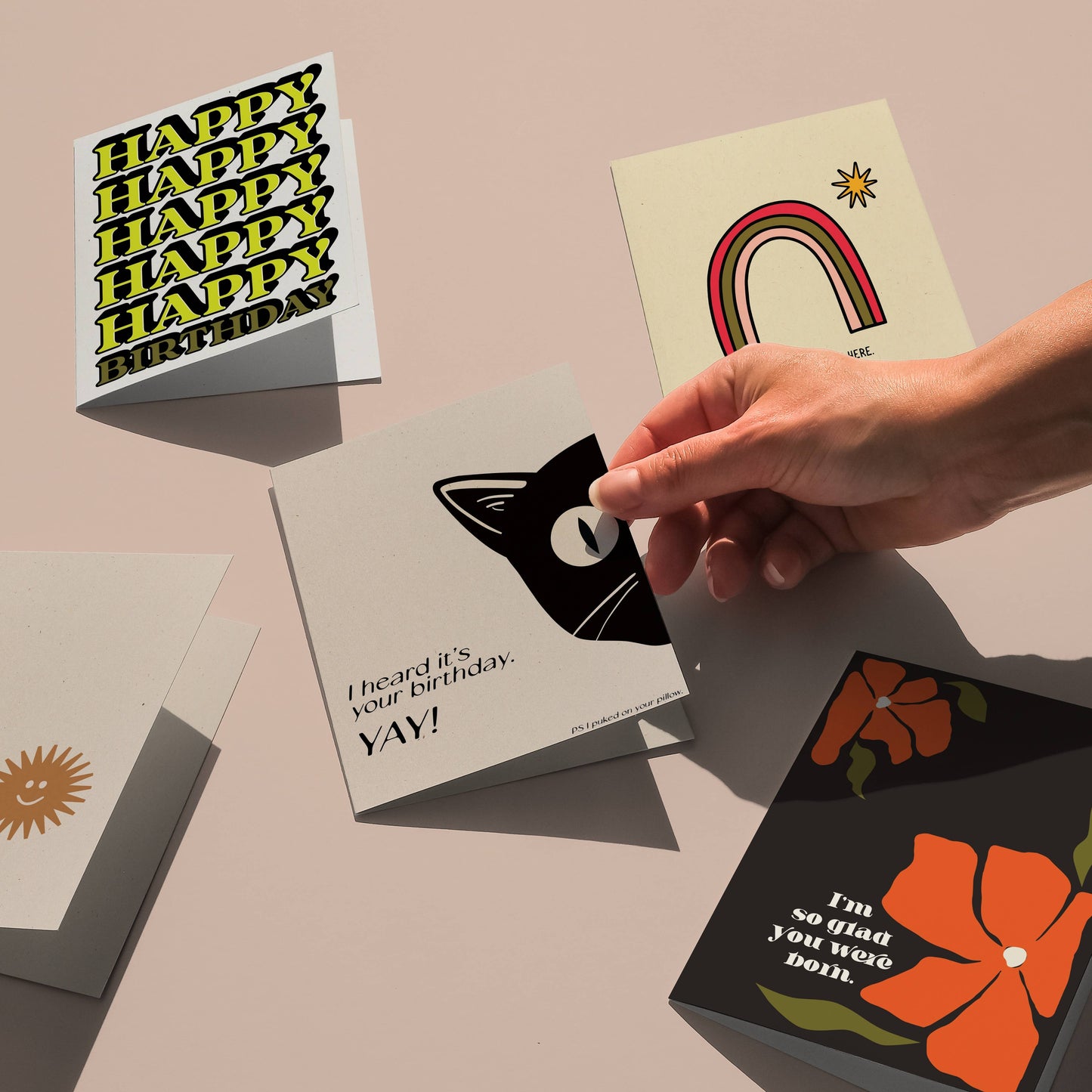 Hand selecting a Happy Birthday - Minimal Letterpressed greeting card from a variety of vibrant card designs.